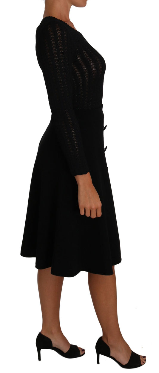 A black knit dress with long sleeves and a sheath silhouette
