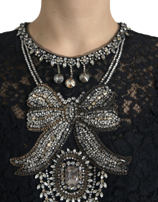 A black lace dress with crystal embellishments and a large bow on the front
