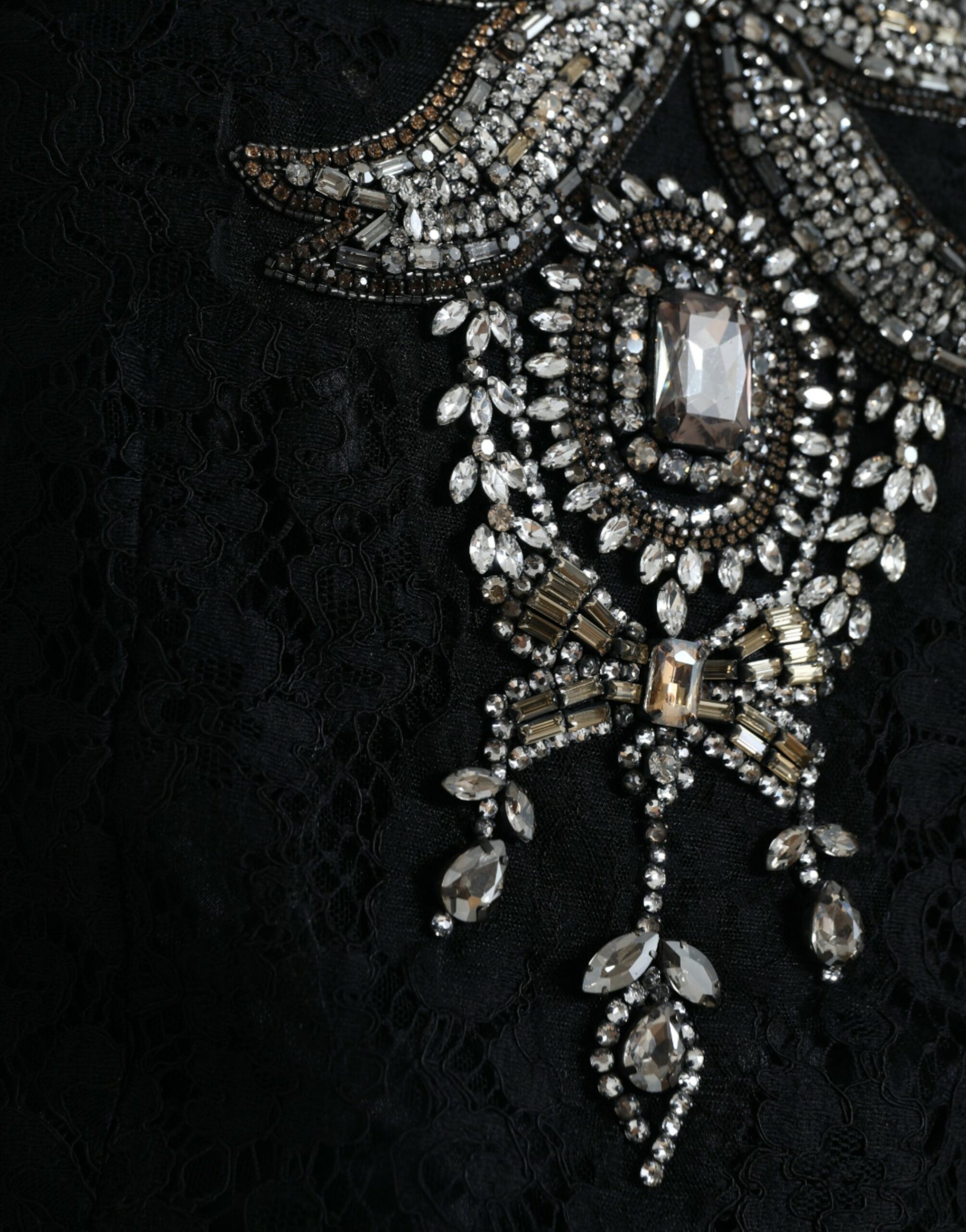 A black lace dress with crystal embellishments and a sheer overlay
