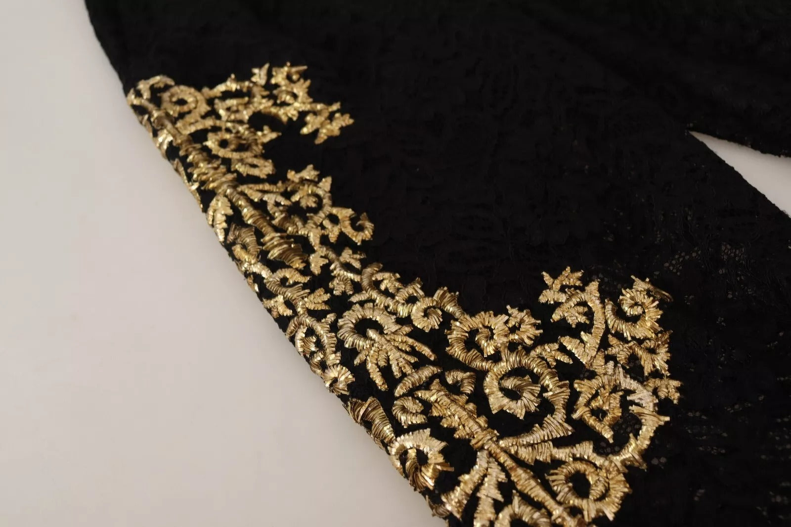 A black lace garment with gold baroque embroidery on the front