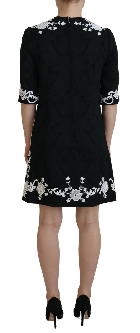A black dress with lace trim and half sleeves, designed by Dolce & Gabbana. It features an A-line silhouette