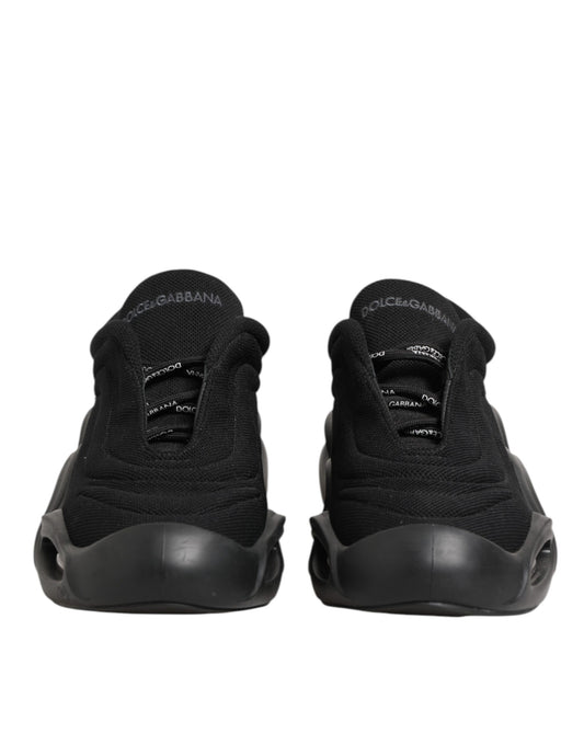 Pair of black lace-up sneakers with white logo on side, designed by Dolce & Gabbana