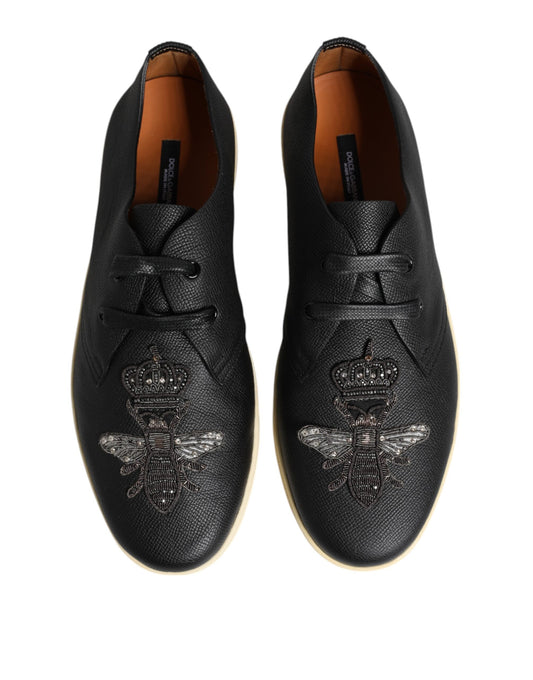 Pair of black shoes with gold accents and embroidered bee design