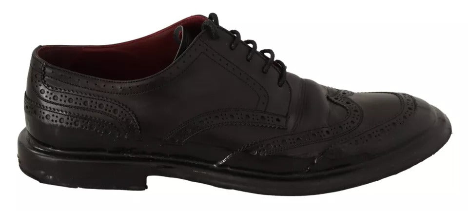 A pair of black leather brogue oxford dress shoes with laces and a small heel