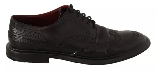 A pair of black leather brogue oxford dress shoes with laces and a small heel