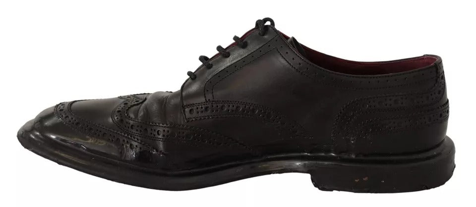 A pair of black leather brogue oxford dress shoes with laces and a small heel