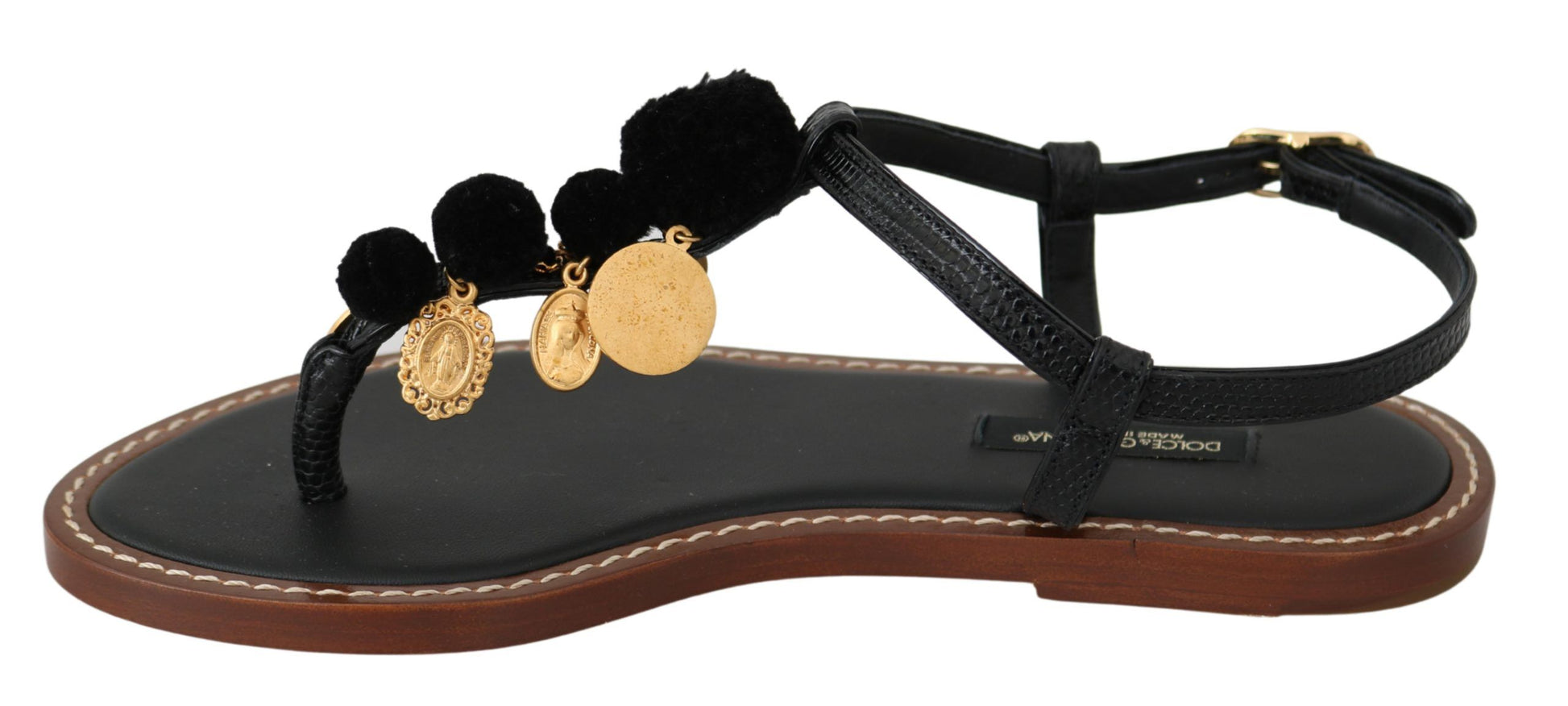 Black sandals with gold accents and a strap over the foot