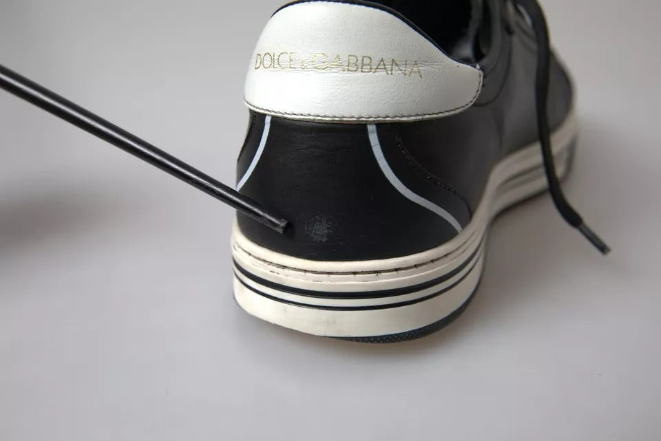 Black leather sneakers with white sole, featuring crown logo on side and laces tied in front