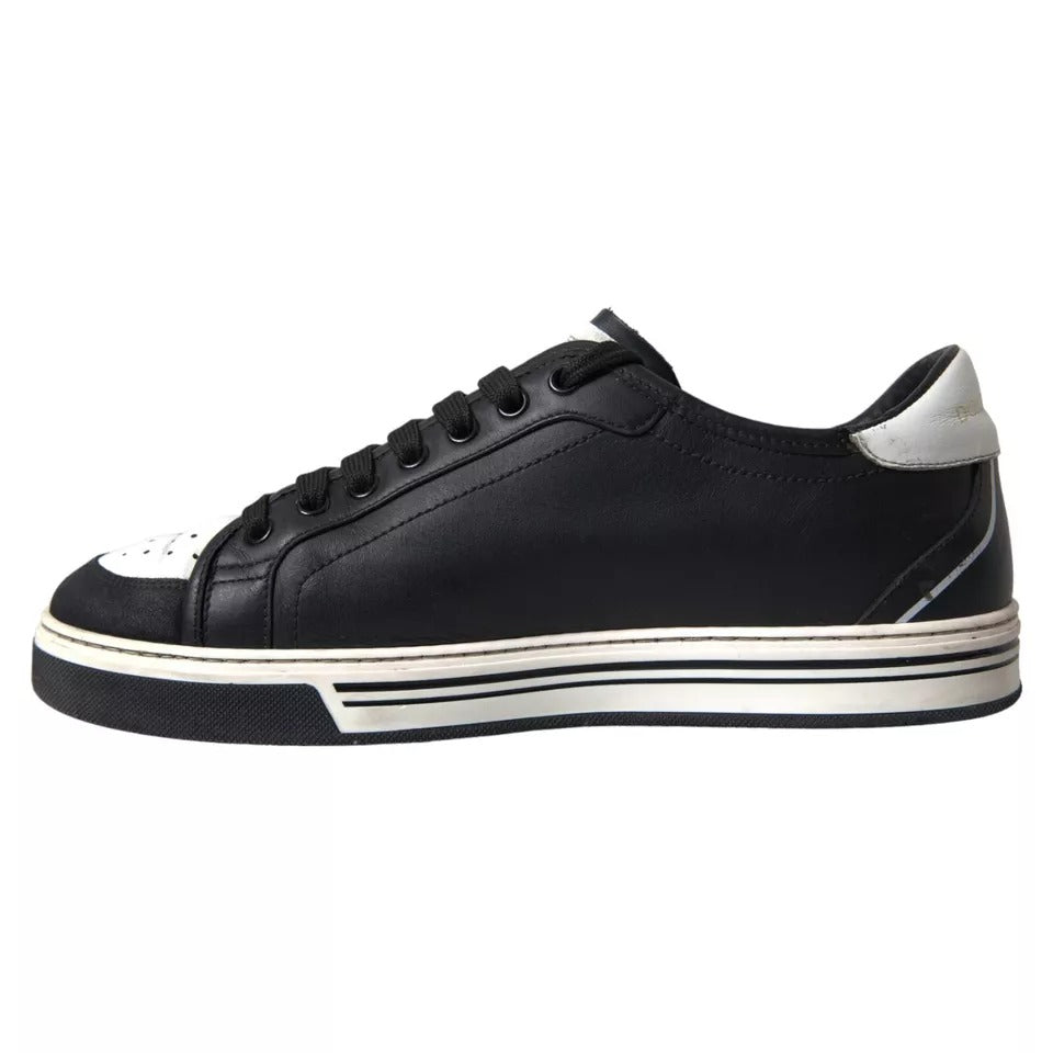 A pair of black leather sneakers with white laces and soles, featuring a crown logo on the side