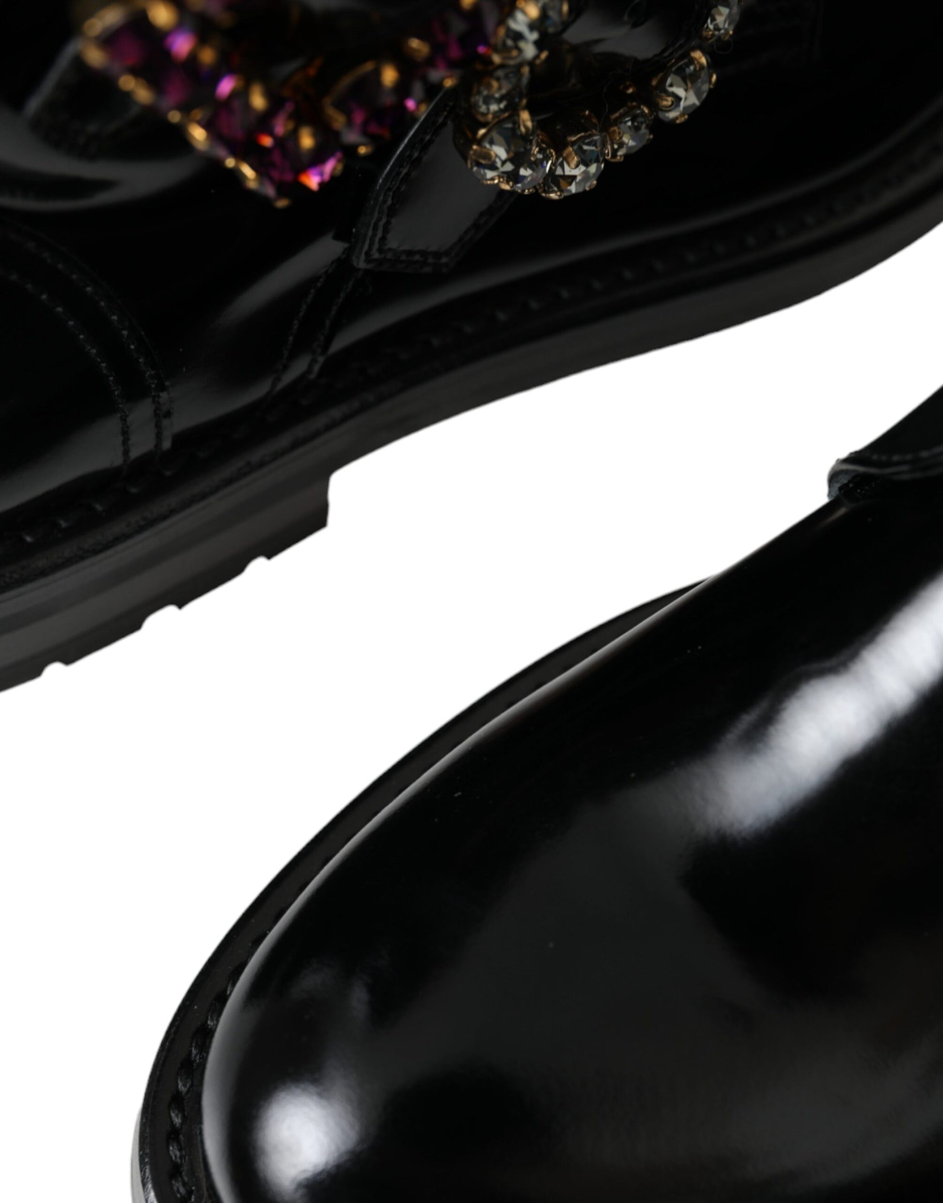 Black leather dress shoe with gold embellishments on laces and heel