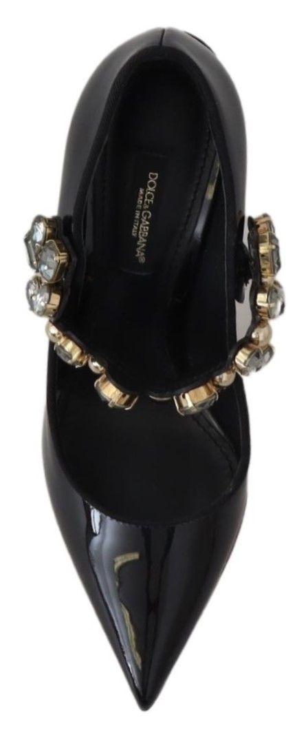 Black high heel shoe with gold accents and a strap around the ankle