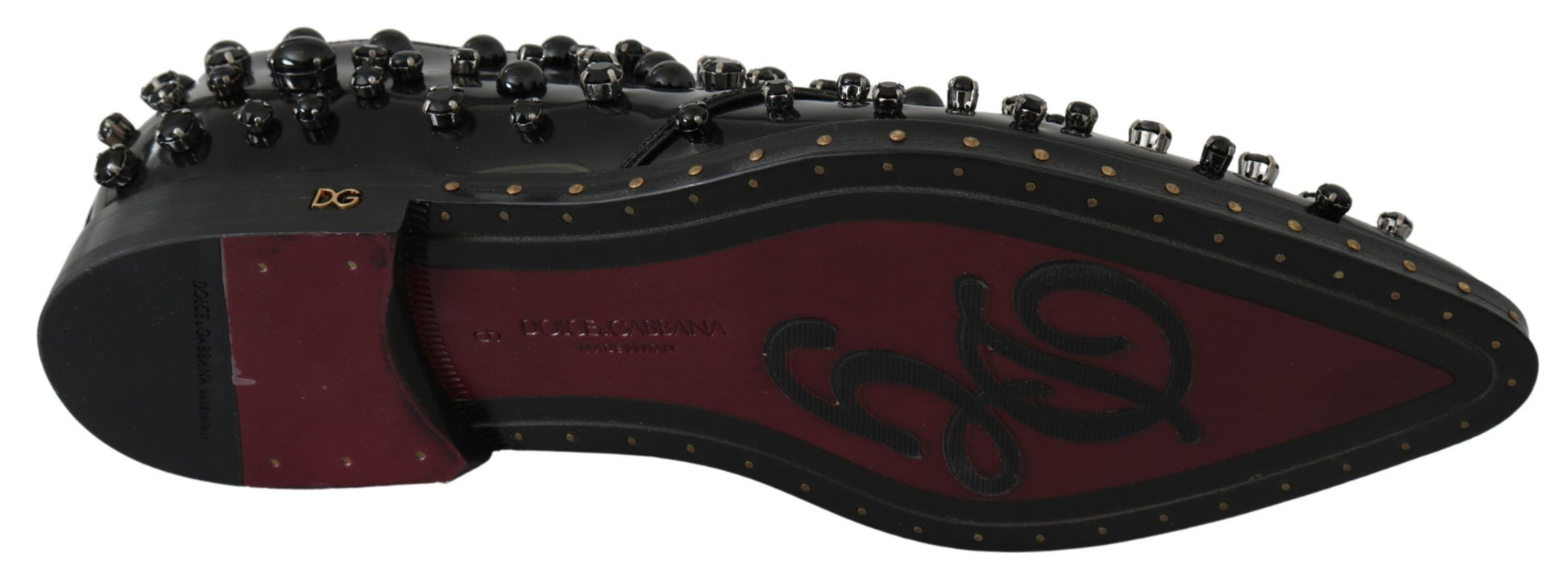 Black and red shoe with multiple studs on sole