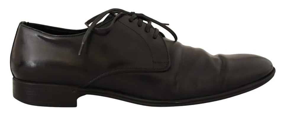 A pair of black leather dress shoes with laces, featuring a derby style and a shiny finish