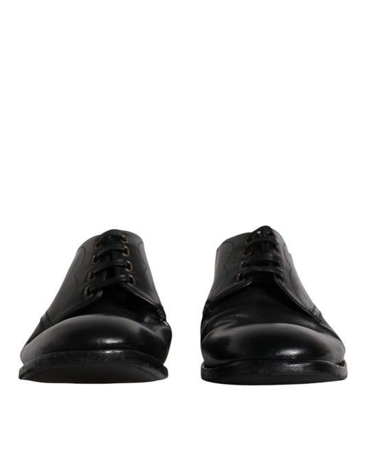 Pair of black leather dress shoes with laces and a shiny finish