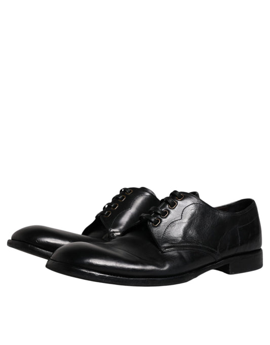 Pair of black leather dress shoes with laces and buckles, featuring a derby style