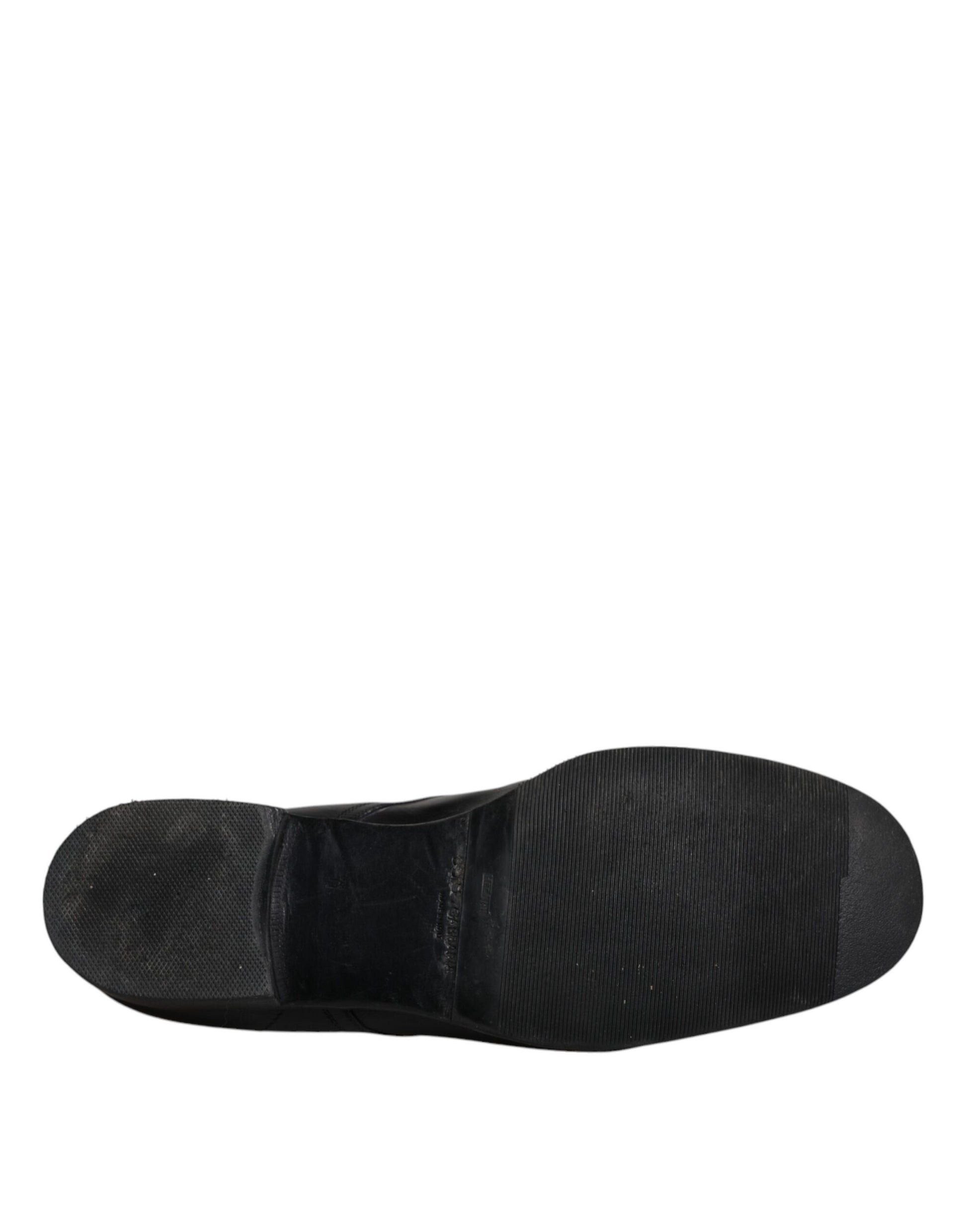 A single black leather dress shoe with a strap across the top, designed for formal wear