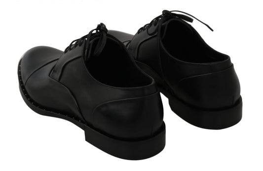 Pair of black leather shoes with laces and a bow on top