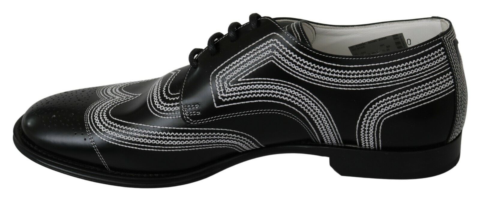 Pair of black patent leather dress shoes with white laces and a decorative pattern on the side