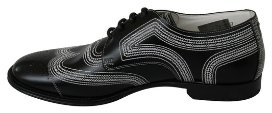 Pair of black patent leather dress shoes with white laces and a decorative pattern on the side
