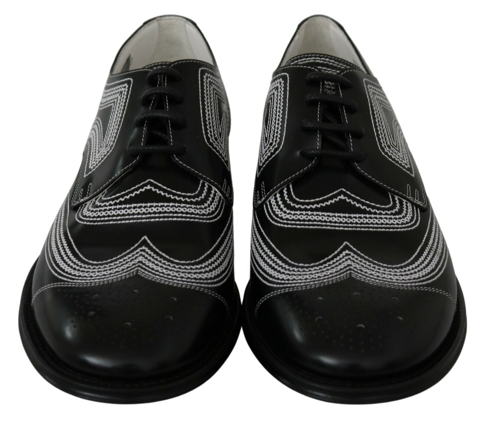 Pair of black dress shoes with white embroidery and laces