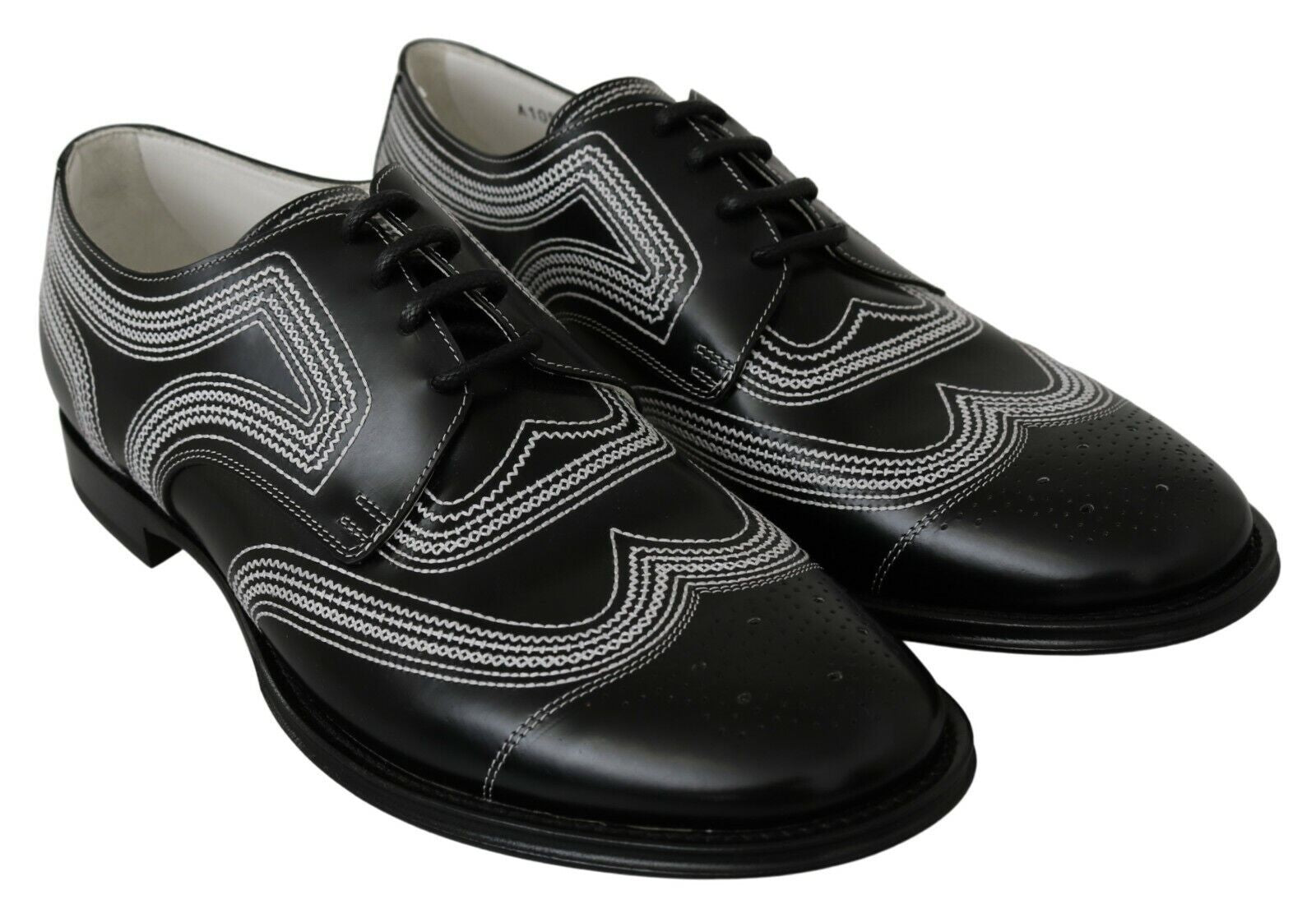Pair of black dress shoes with white laces and patterned design on toe cap