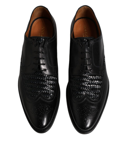 Pair of black leather dress shoes with laces and wingtip design