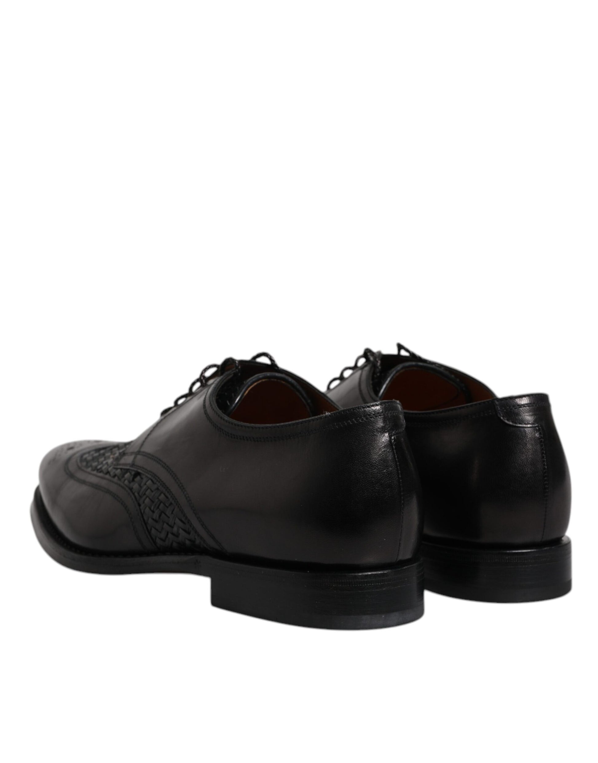 Pair of black leather dress shoes with laces, wingtip design and a small bow on the toe