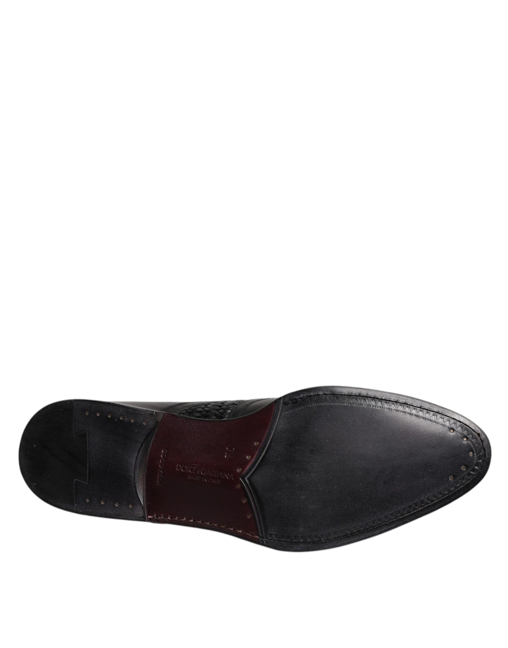A pair of black leather dress shoes with red accents, laces and a wingtip design