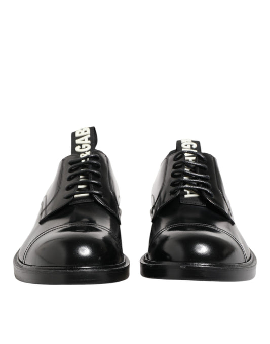 Pair of black leather lace-up shoes with silver buckles, designed by Dolce & Gabbana