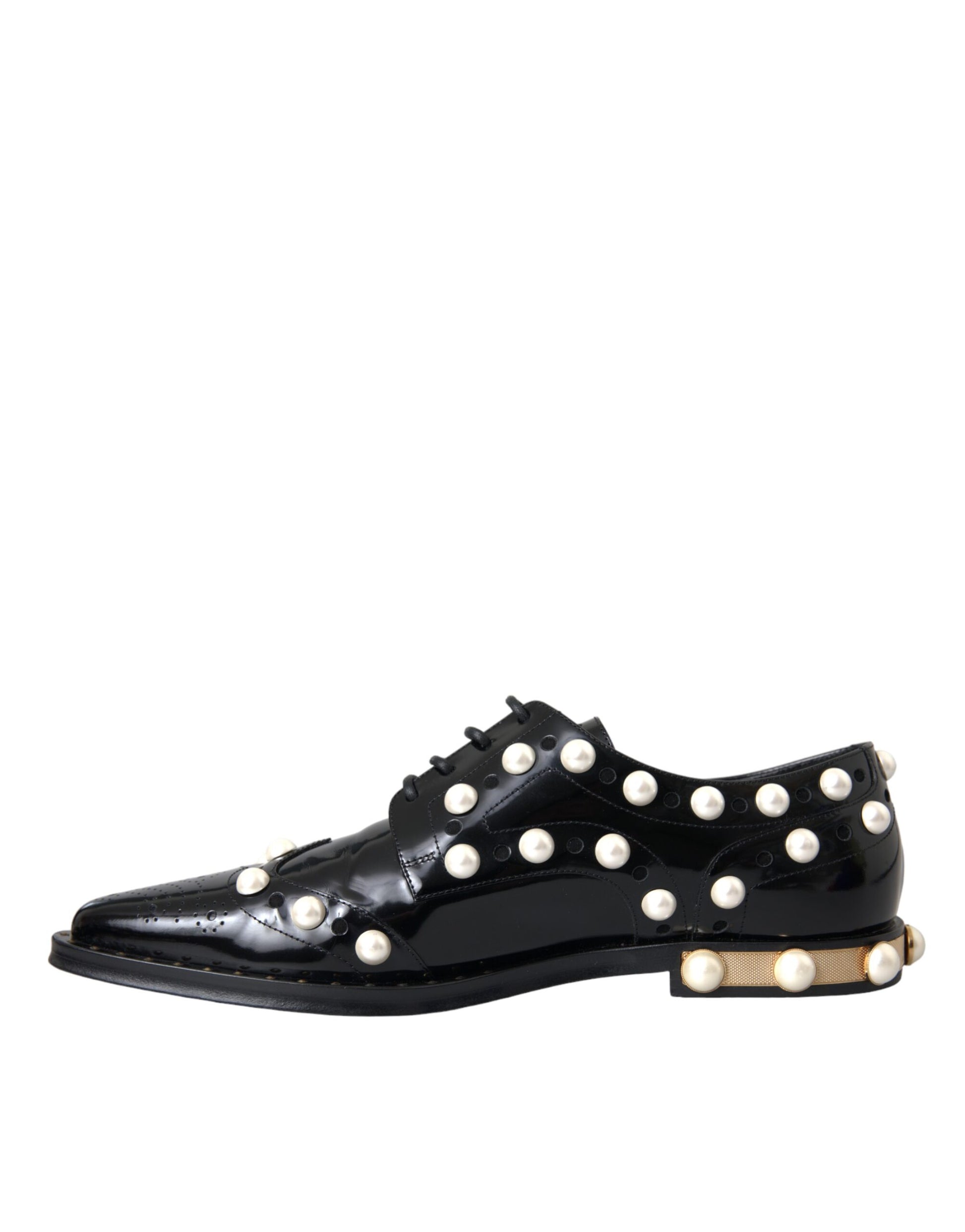 A pair of black leather shoes with faux pearls and gold accents