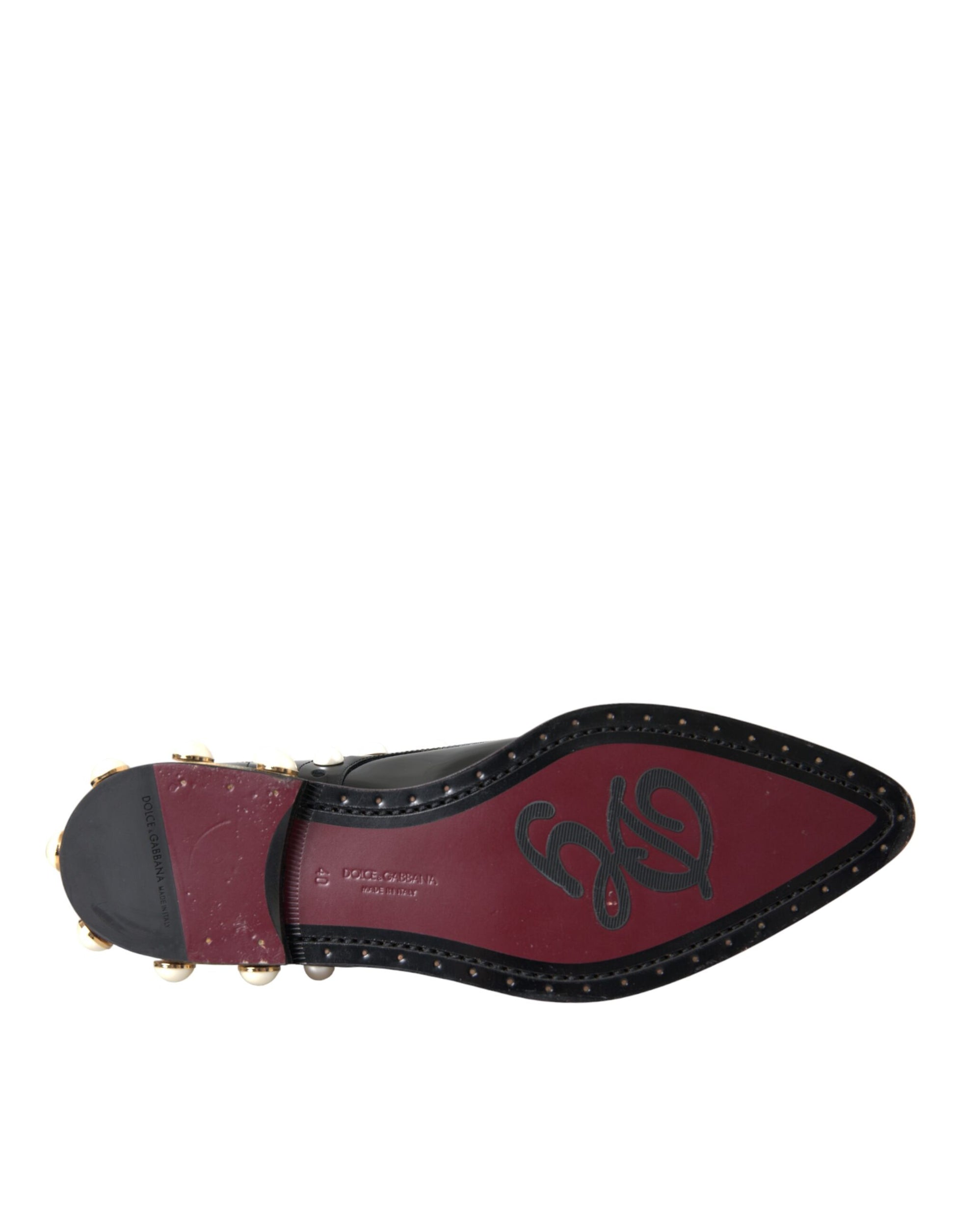 A pair of black leather faux pearl dress broques with a red sole