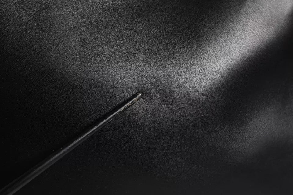 Black metal object on dark surface