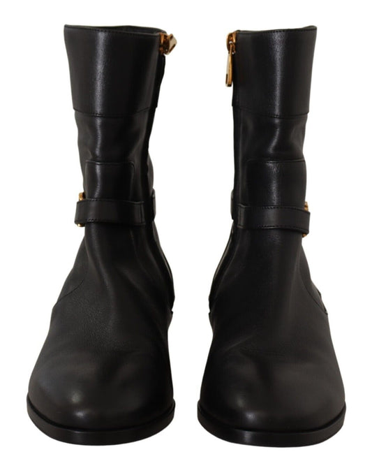 Pair of black leather boots with gold buckles and straps