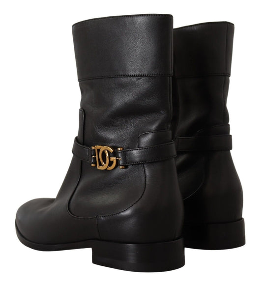 Pair of black leather boots with gold buckle and logo on side