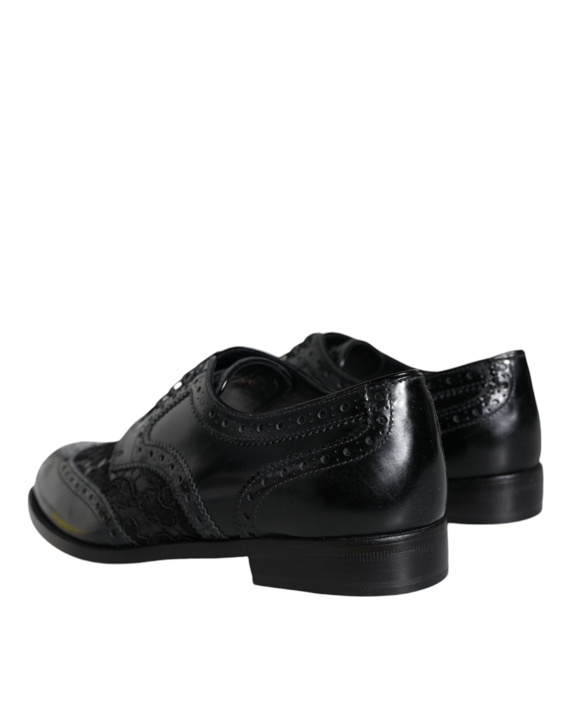 Pair of black leather shoes with floral lace design and rubber soles