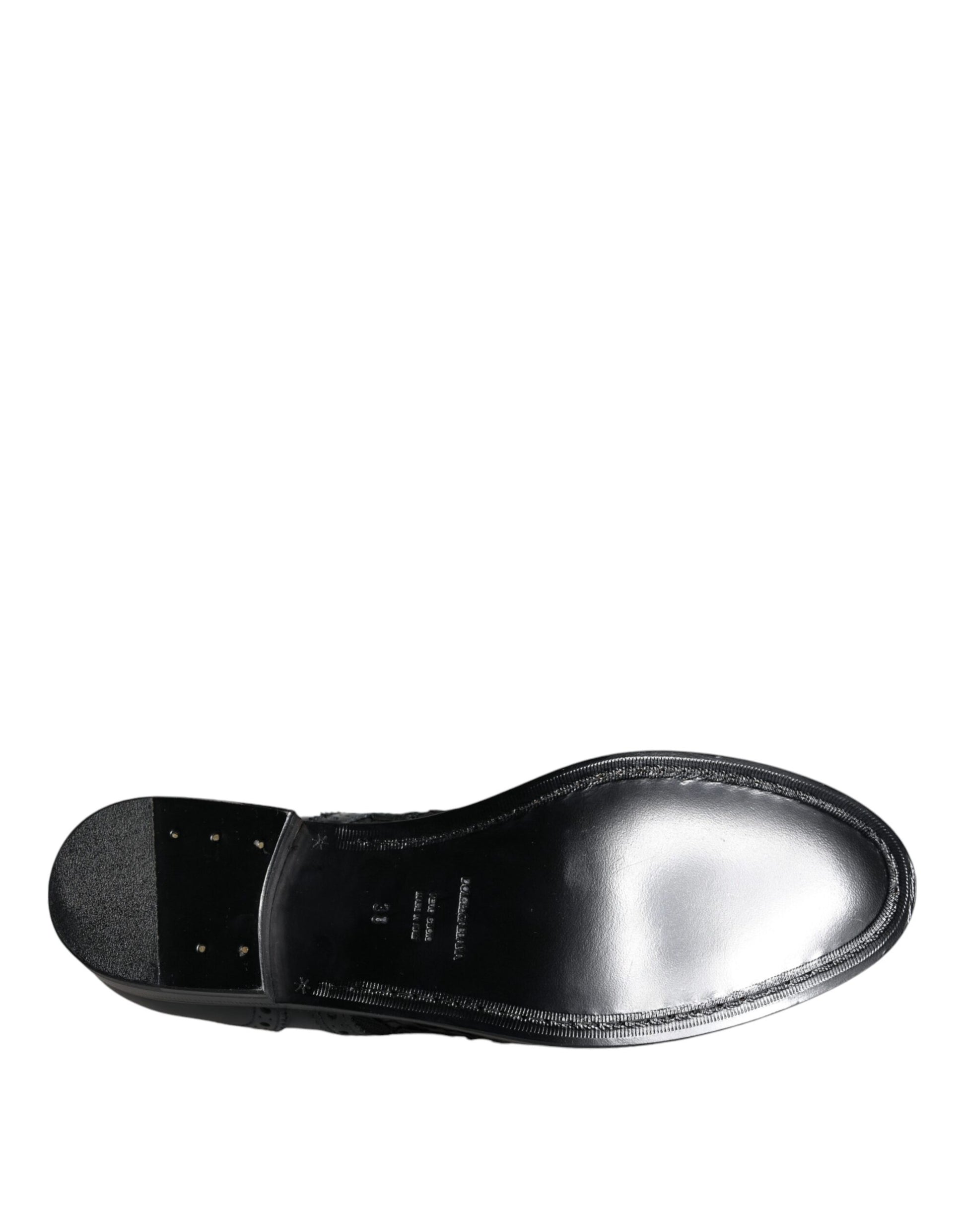 A pair of black leather dress shoes with floral lace detailing from the brand Dolce & Gabbana