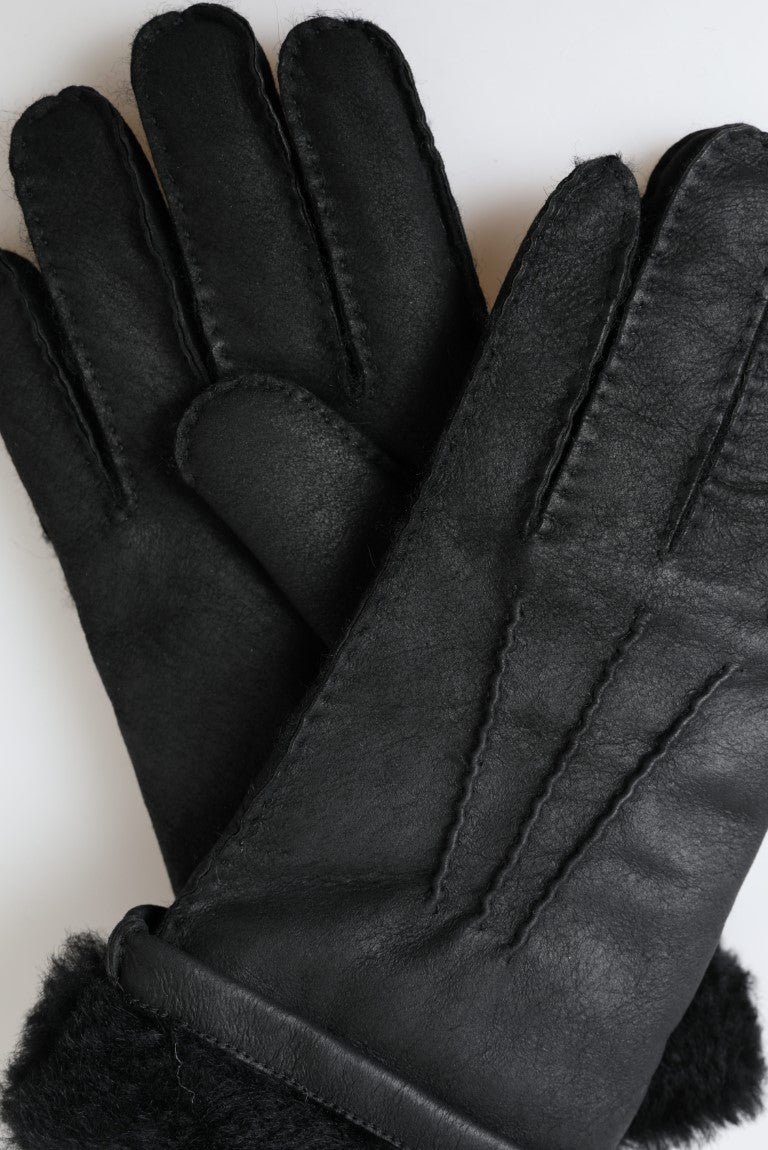 Pair of black gloves on white surface