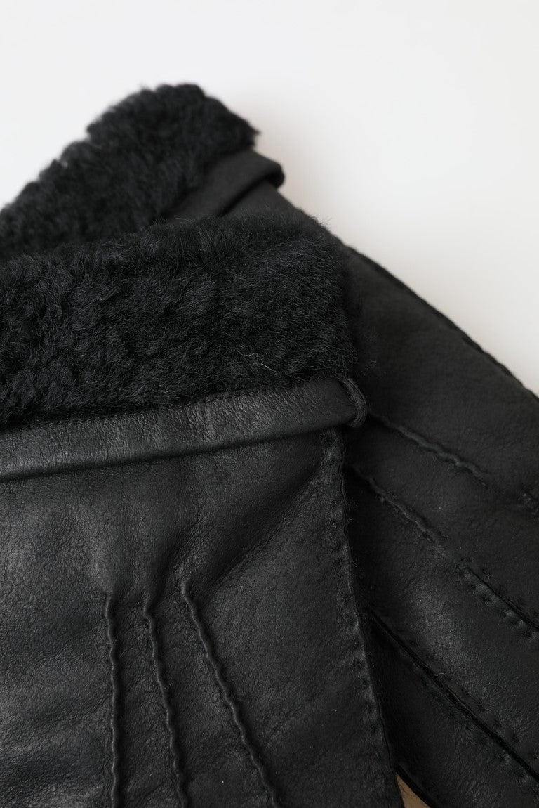 Black leather gloves on white surface