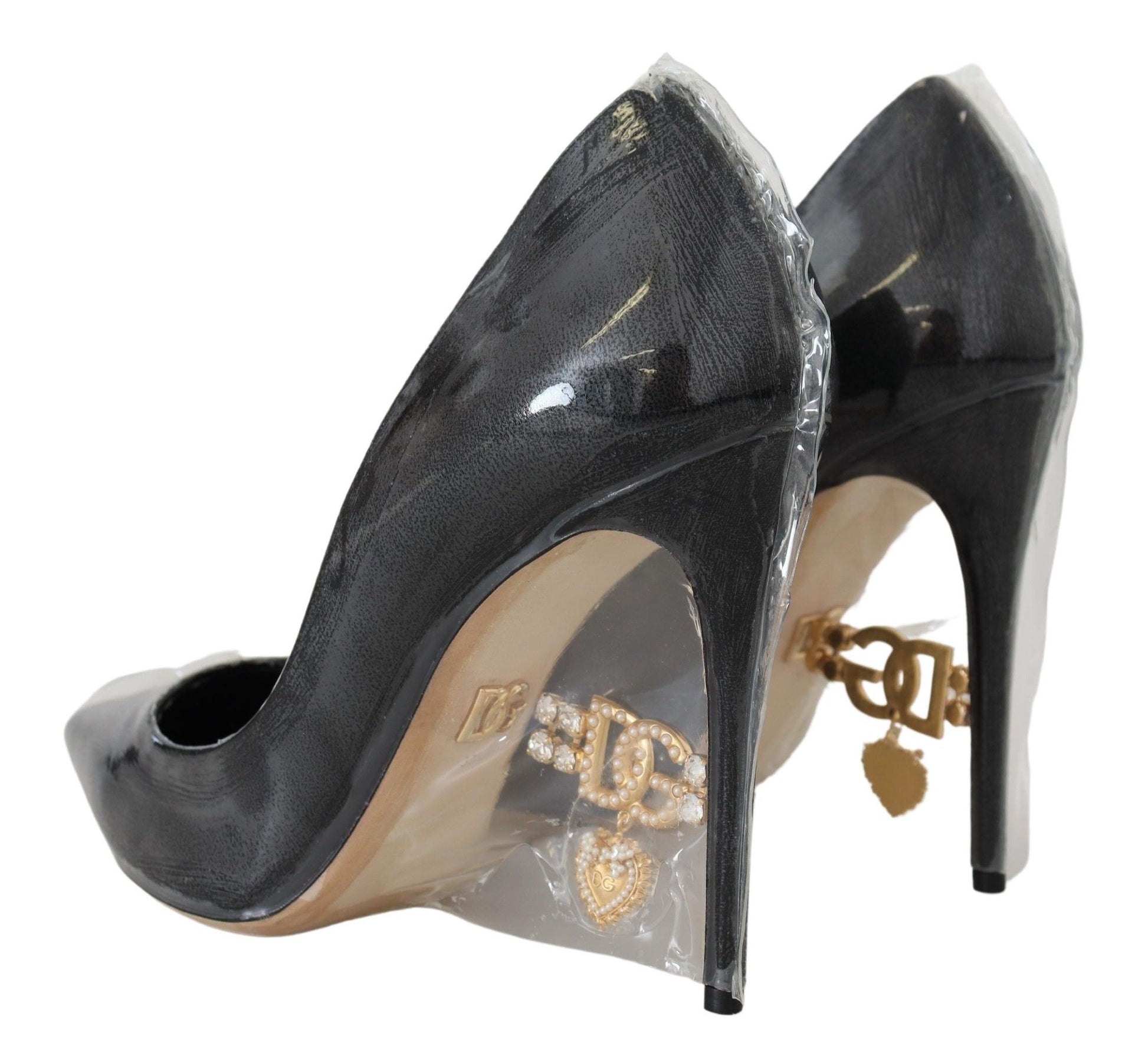 Pair of black high heel shoes with gold accents and a clear plastic bag
