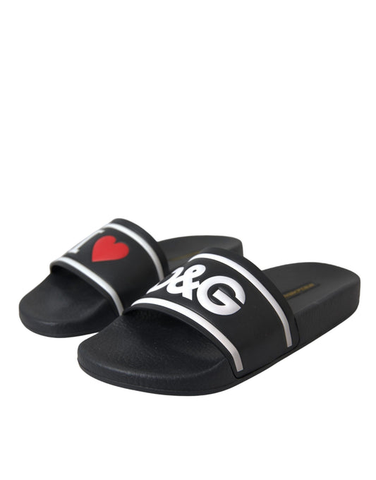Pair of black sandals with white stripes and a heart design on the sole