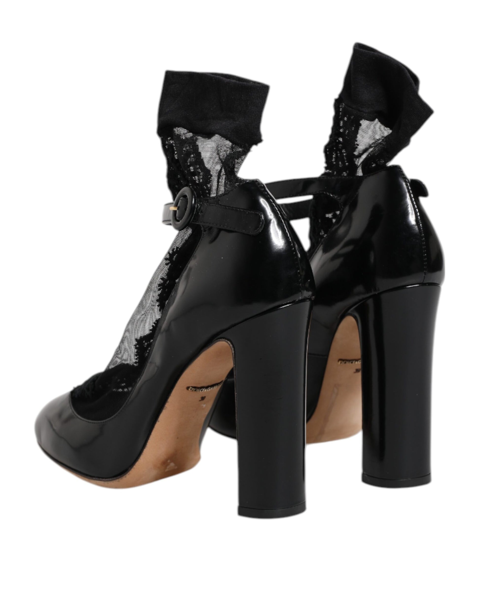 Pair of black high heel shoes with brown soles and silver buckles