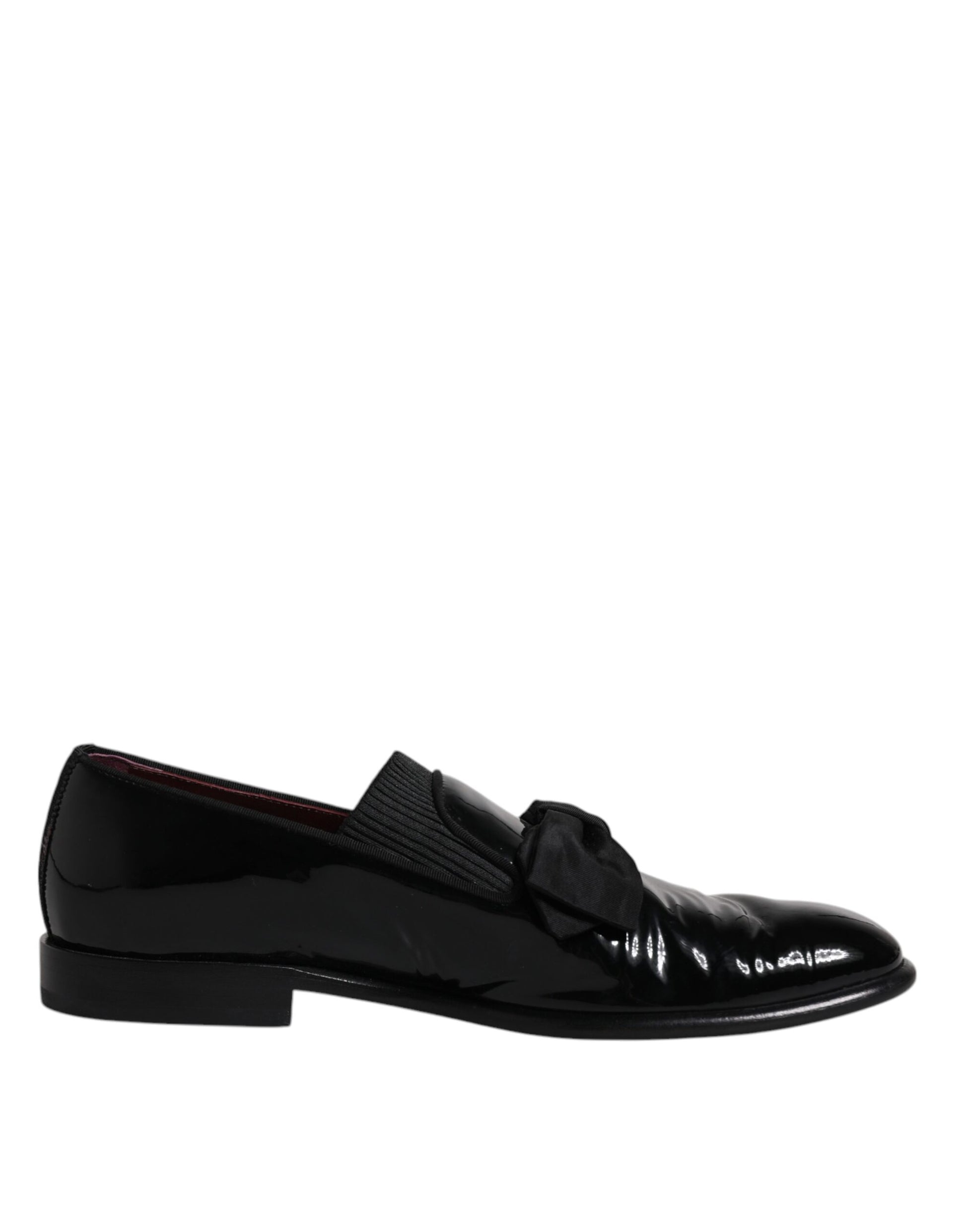 A pair of black leather loafers with a shiny finish, featuring a bow tie design on the vamp