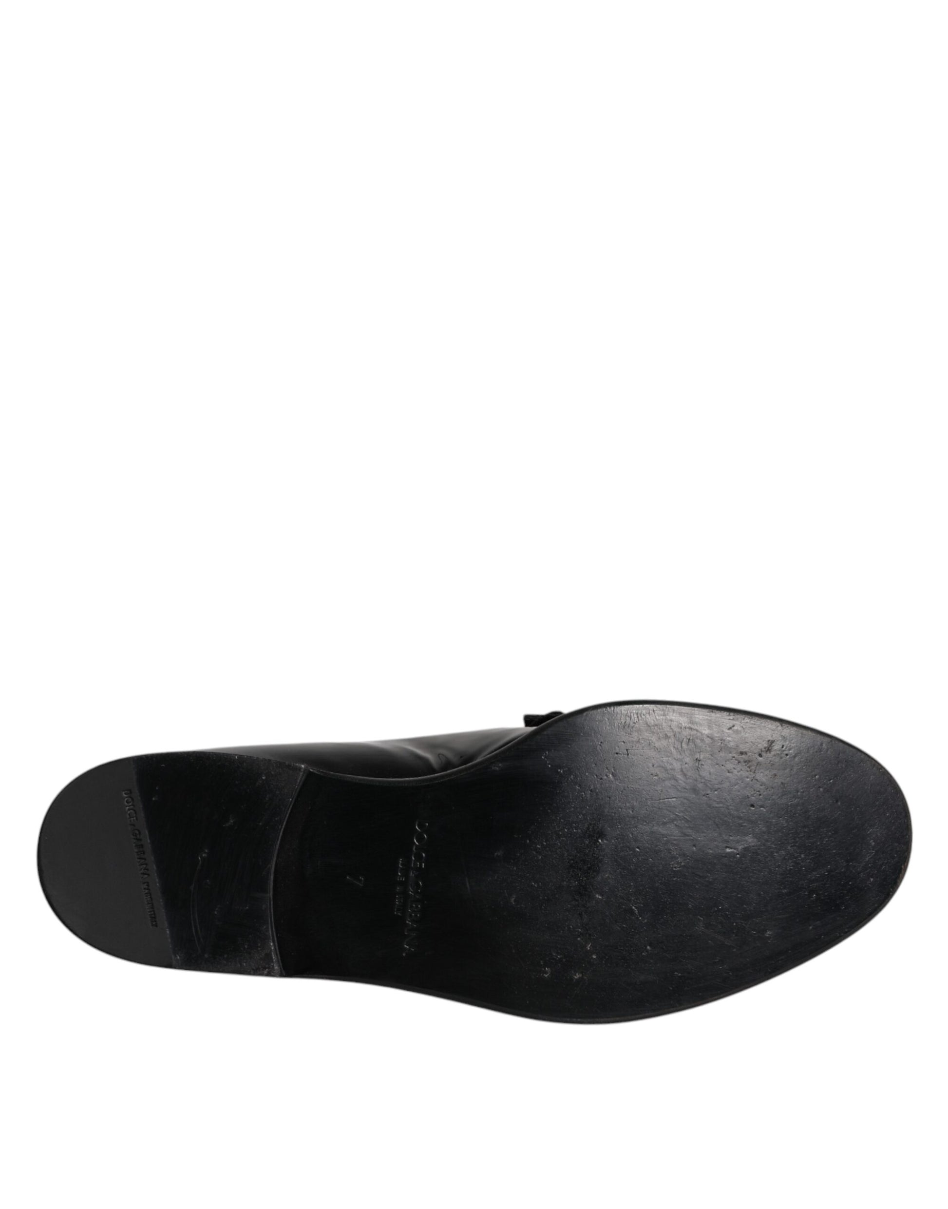 A single black leather loafer shoe with a strap across the top, designed for men's formal wear