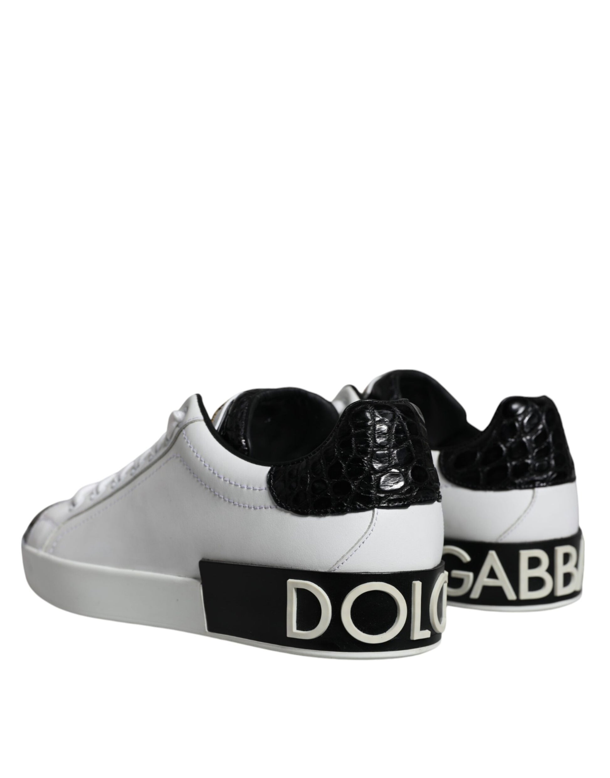 White sneakers with black leather accents and gold logo on side