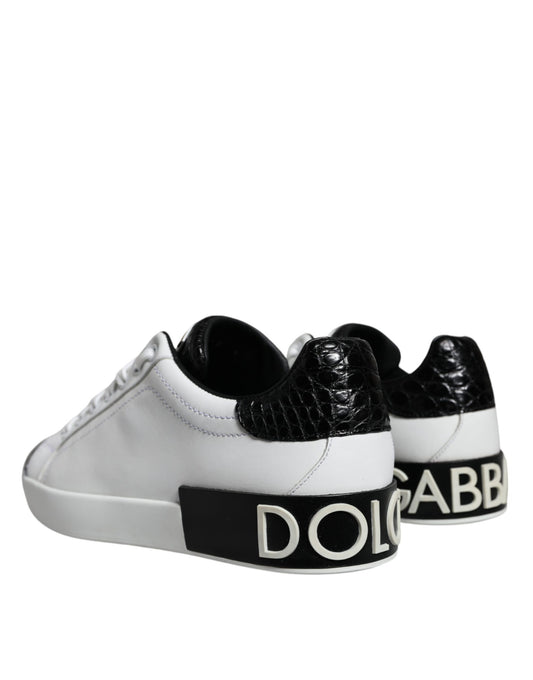 White sneakers with black leather accents and gold logo on side