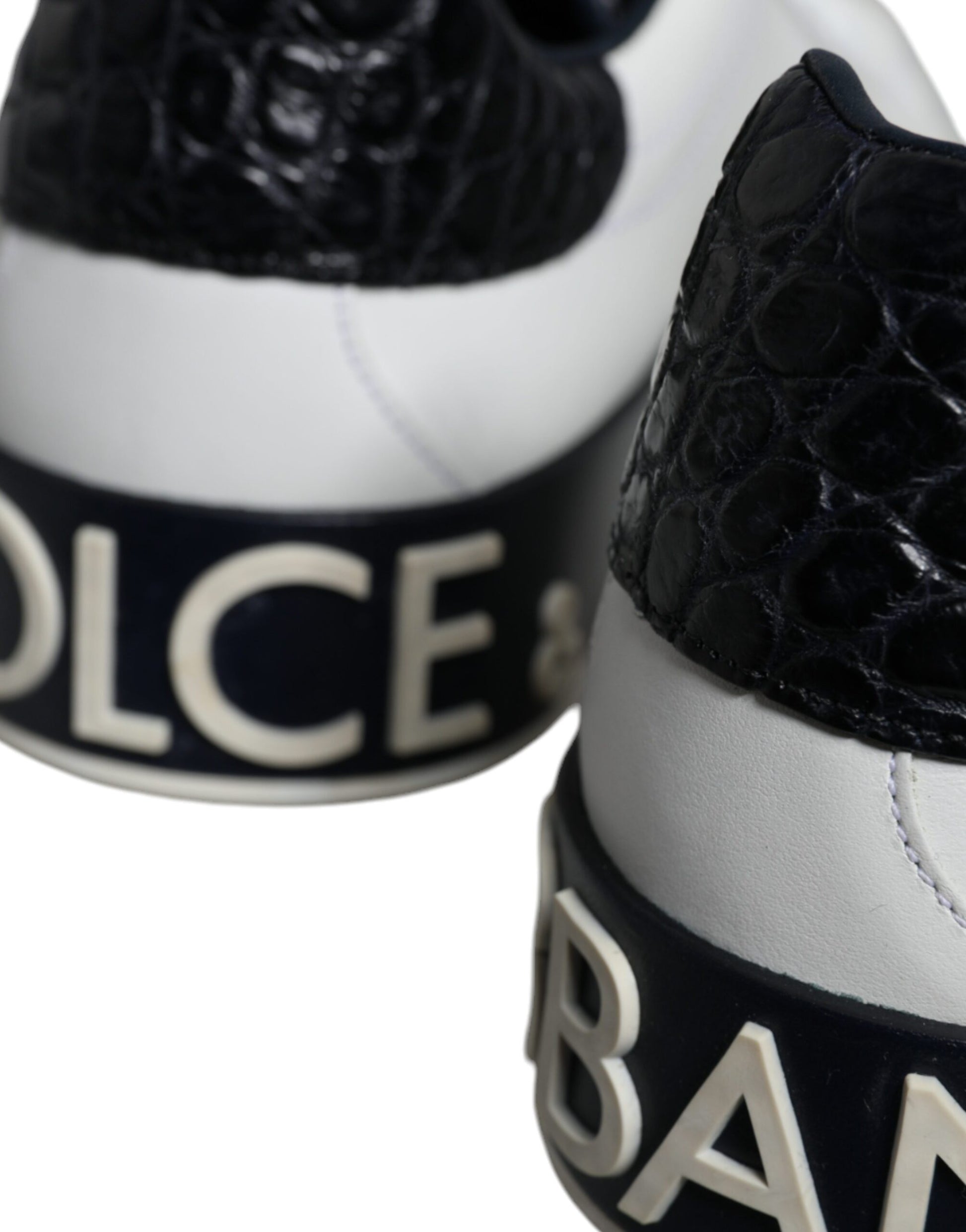 A pair of black leather sneakers with a logo on the side, featuring white laces and a white sole