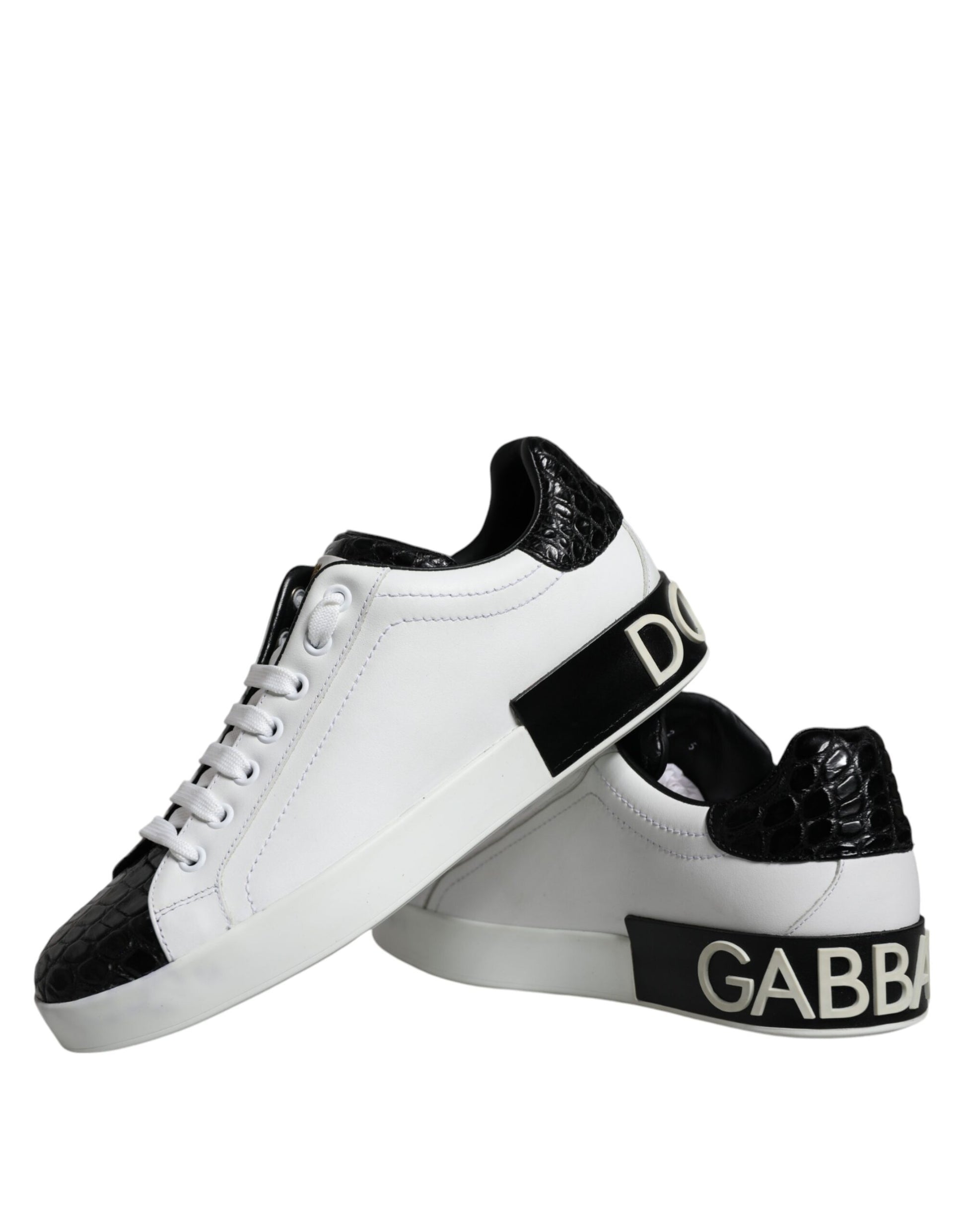 White sneakers with black leather accents and gold logo on side