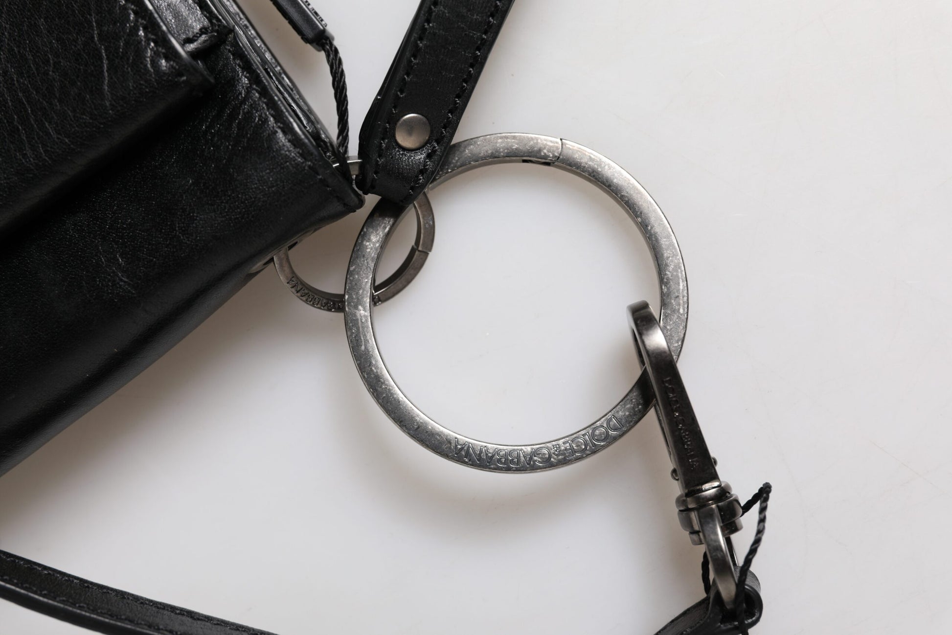 Metal key ring attached to black leather purse strap