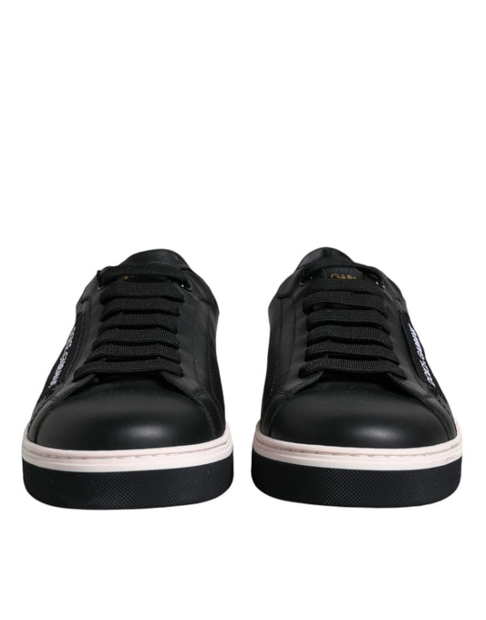Pair of black sneakers with white soles and laces