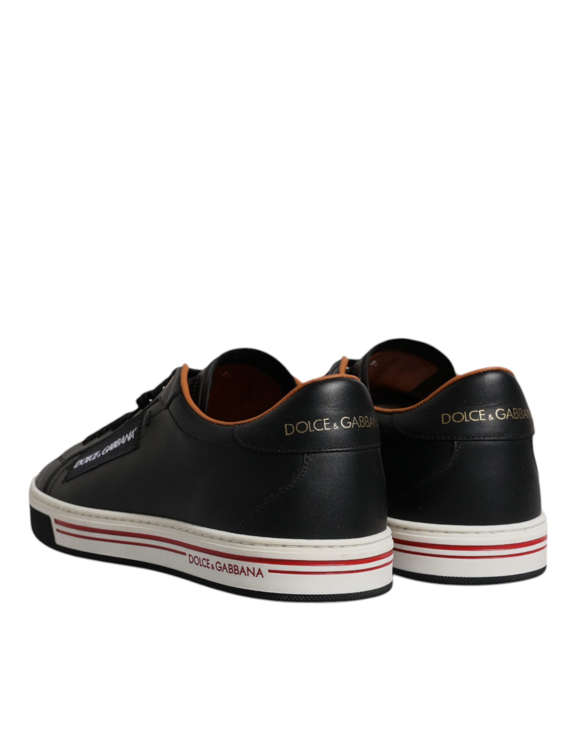 Pair of black sneakers with white soles and red stripes on sides